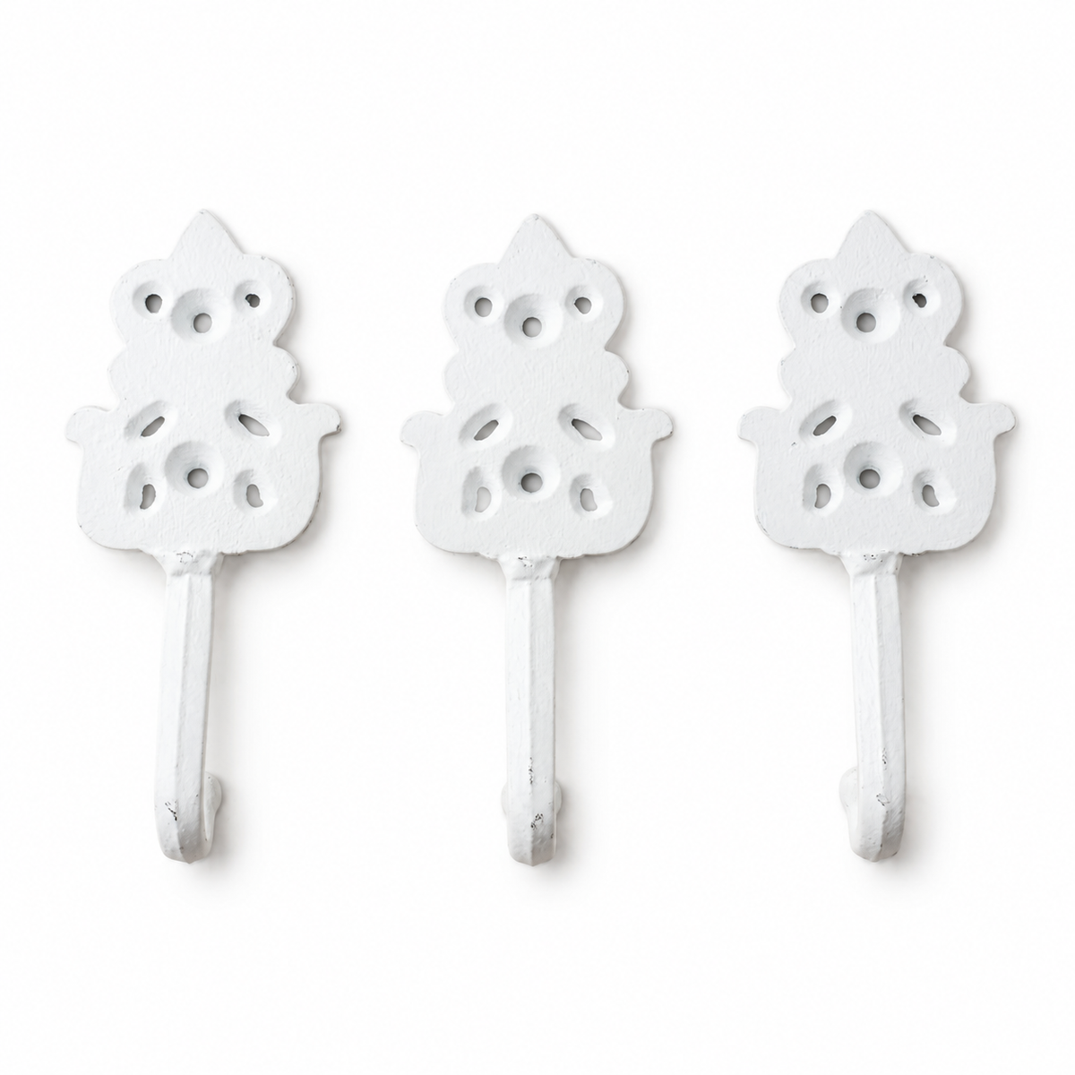 Back view of three distressed white cast iron wall hooks on a clean white background